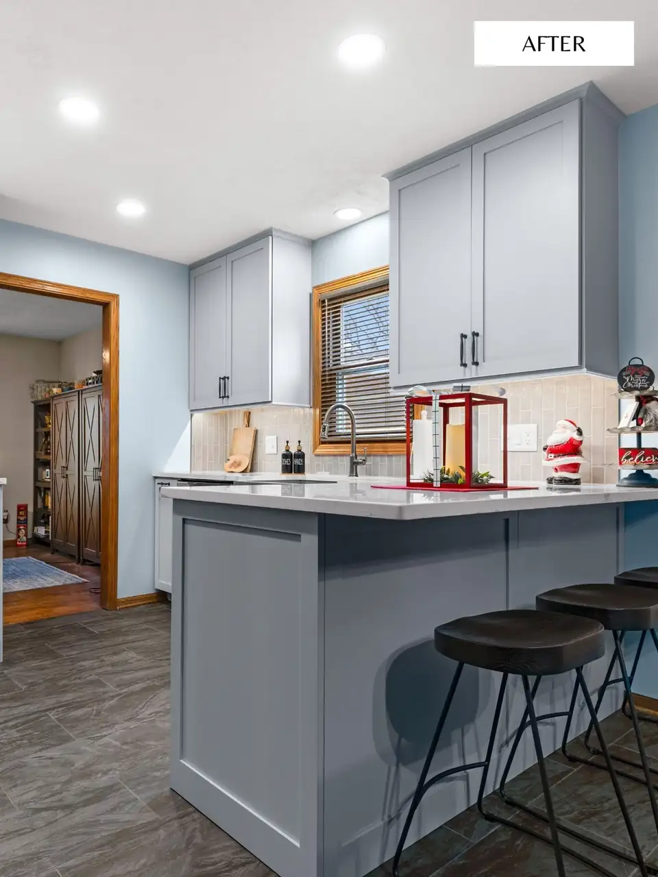 Kitchen remodeling Machesney Park IL: gray-blue shaker cabinets with a matching peninsula, light counters and black barstools