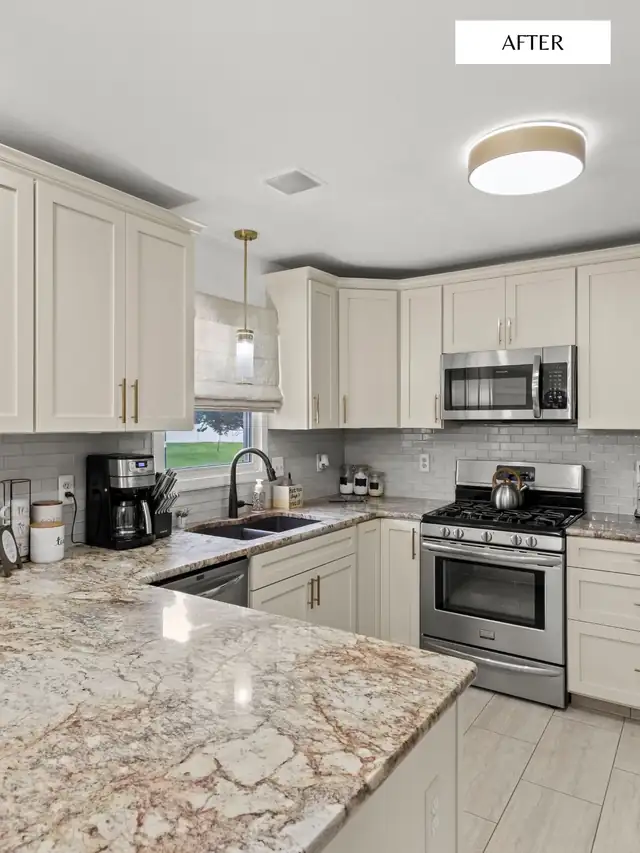 Kitchen with cream shaker cabinets, granite countertops, white subway tile and stainless gas range
