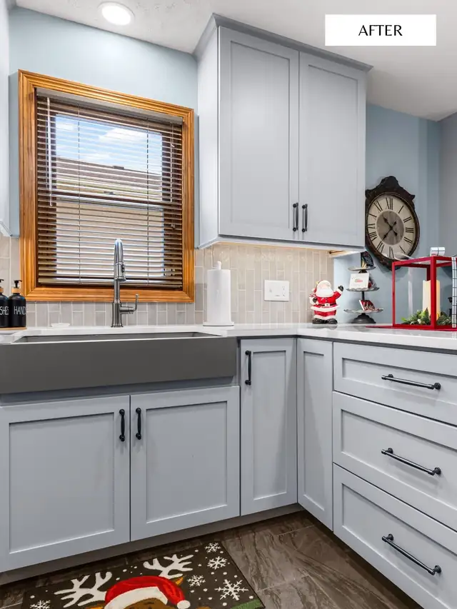 Light gray shaker cabinets with gray farmhouse sink, black pulls and tile backsplash