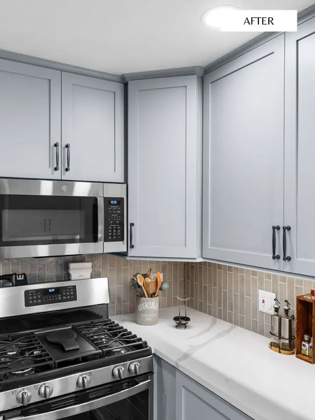 Remodeled kitchen with gray shaker cabinets, stainless gas range, tan vertical tile backsplash and white counters